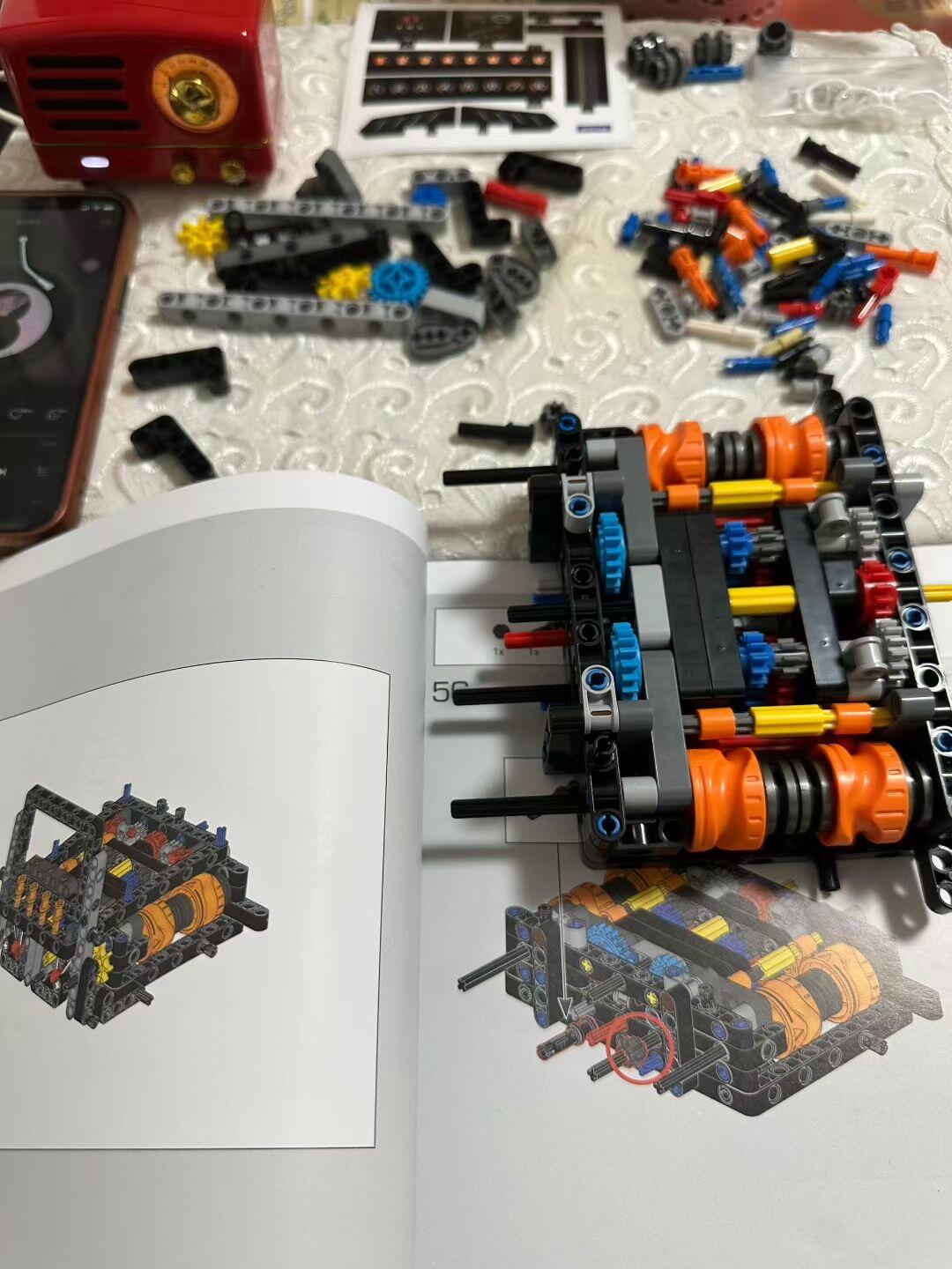 Open Brick Leon manual page next to sorted parts and the in-progress gearbox subassembly