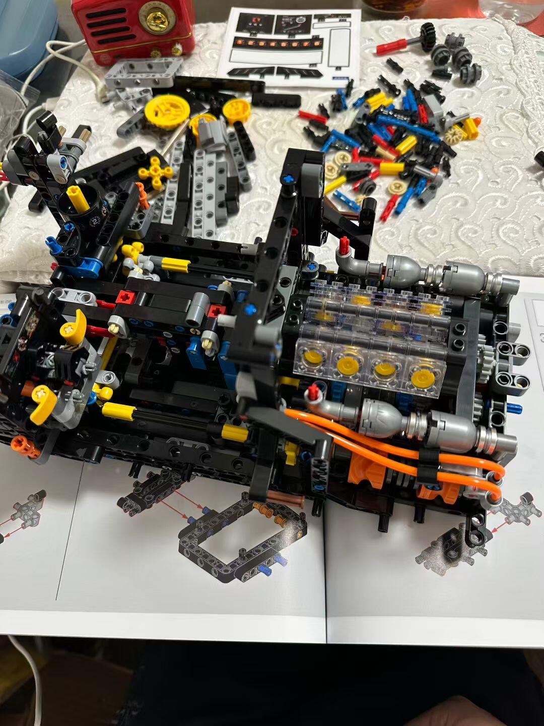 Manual page beside the mid-build chassis with engine bay taking shape