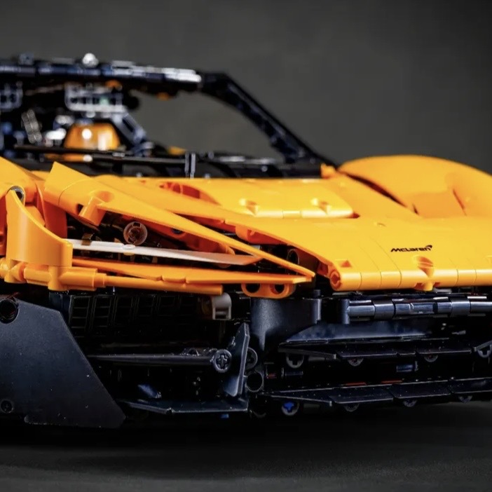 Orange MOC 03 side profile close-up with McLaren badge and front splitter detail