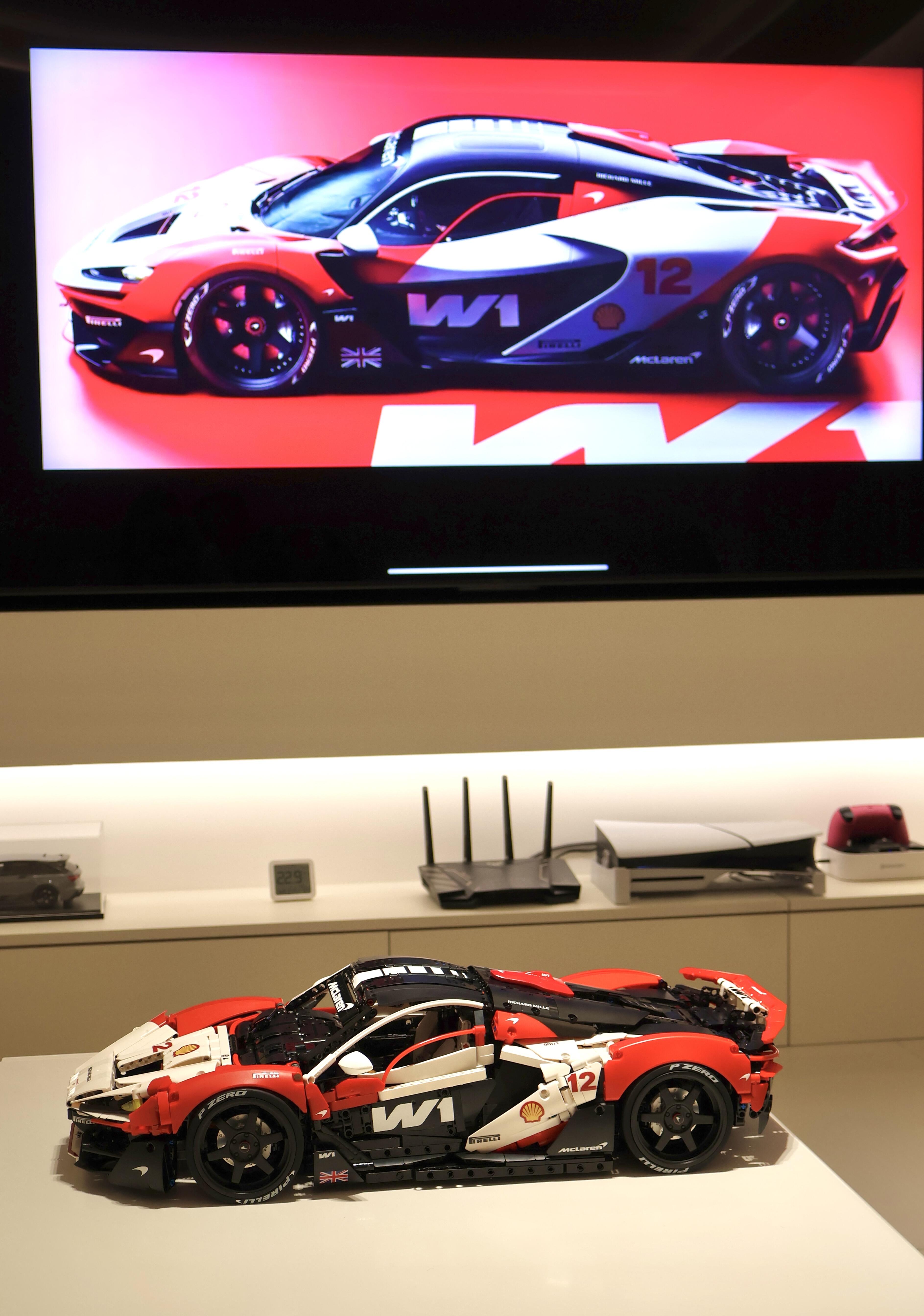 Race livery MOC 03 side view on desk with the original race car displayed on screen behind
